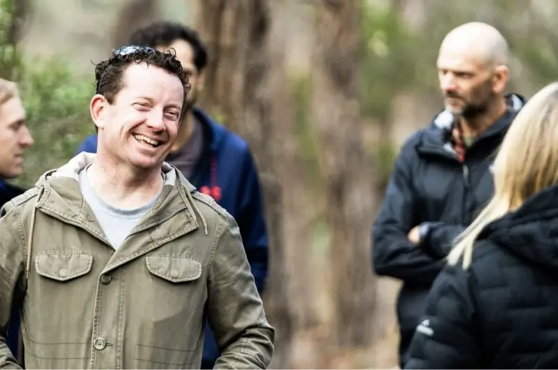 Group of people talking and smiling in the woods
