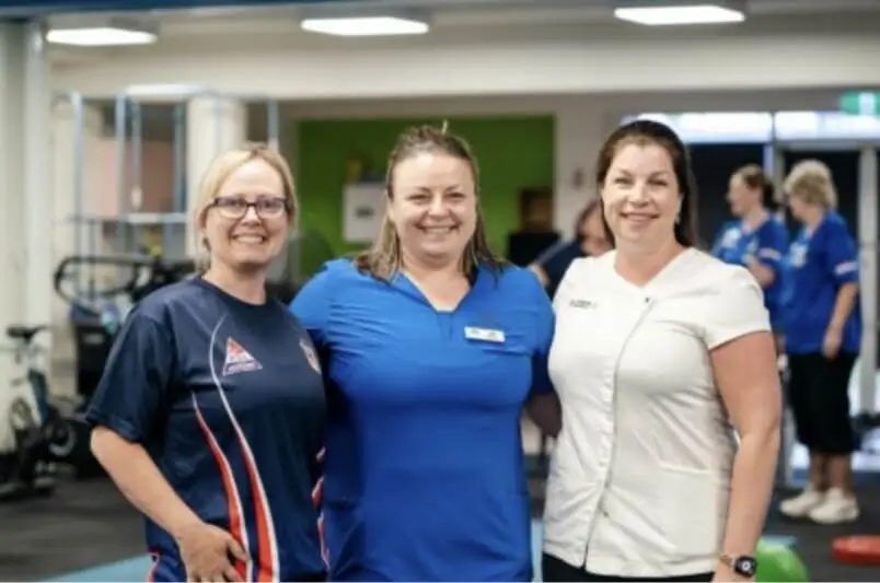 Happy people standing together at a gym