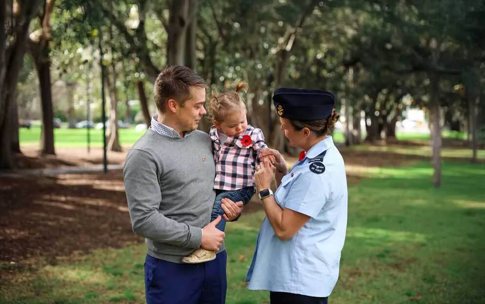 Family with small child wearing a poppy